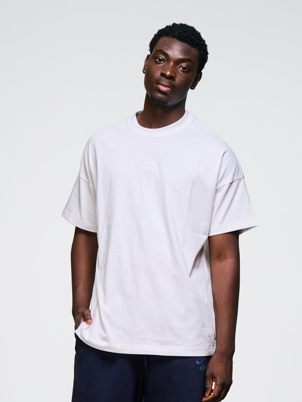 t-shirt Fabricio Airness blanc porté par un homme debout en tenue de sport